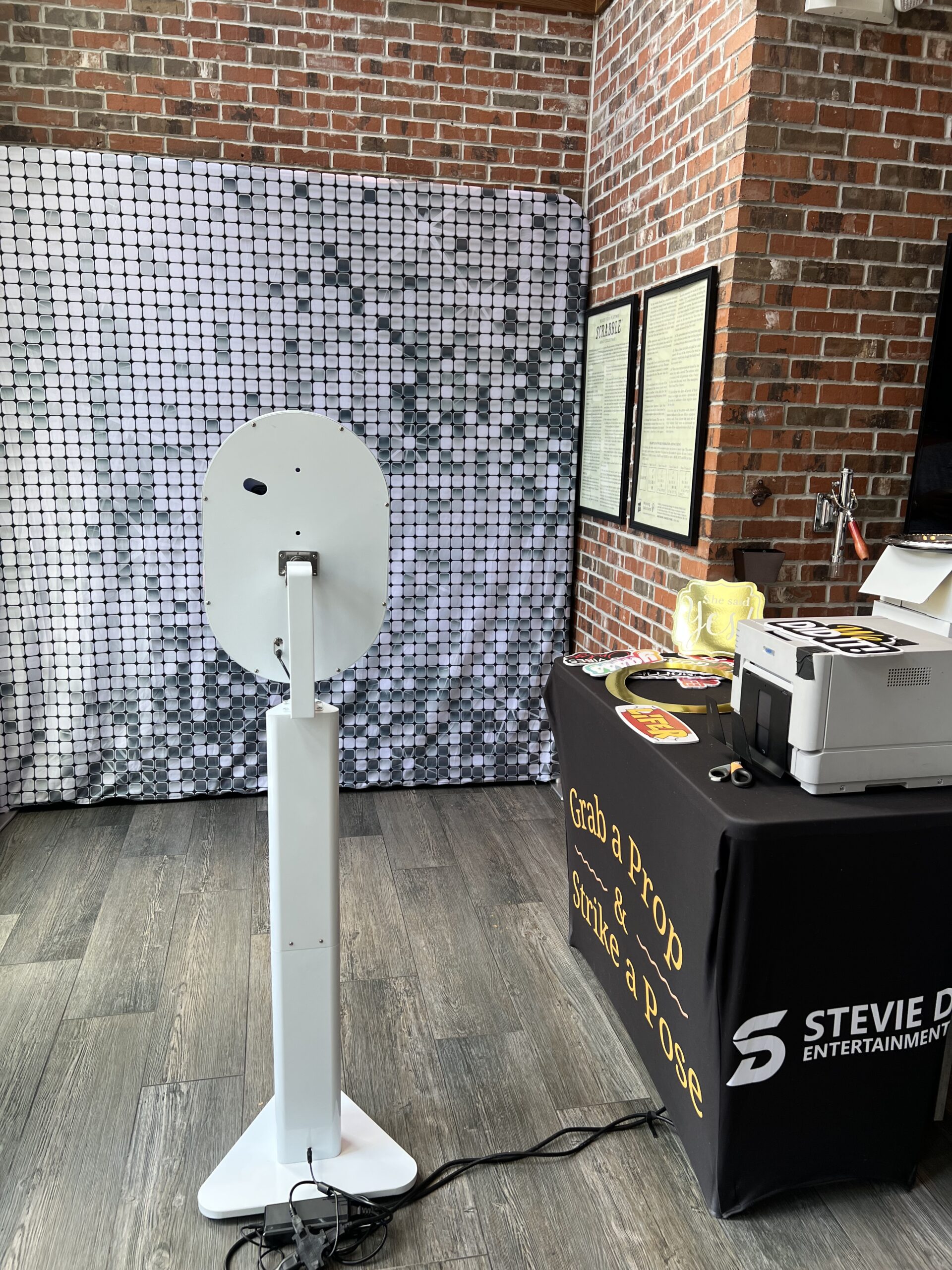 Photo booth kiosk with shimmer wall backdrop and props table at NYC event